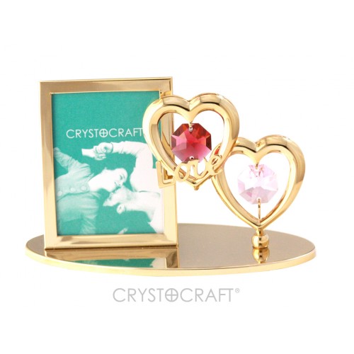 Fotorāmītis ar divām sirdīm, uz pamatnes, ar SWAROVSKI kristāliem, zelta pārklājums. Izmērs 10 x 4,5 x 7,5 cm. Fotogrāfijas izmērs: 3,7*5 cm.